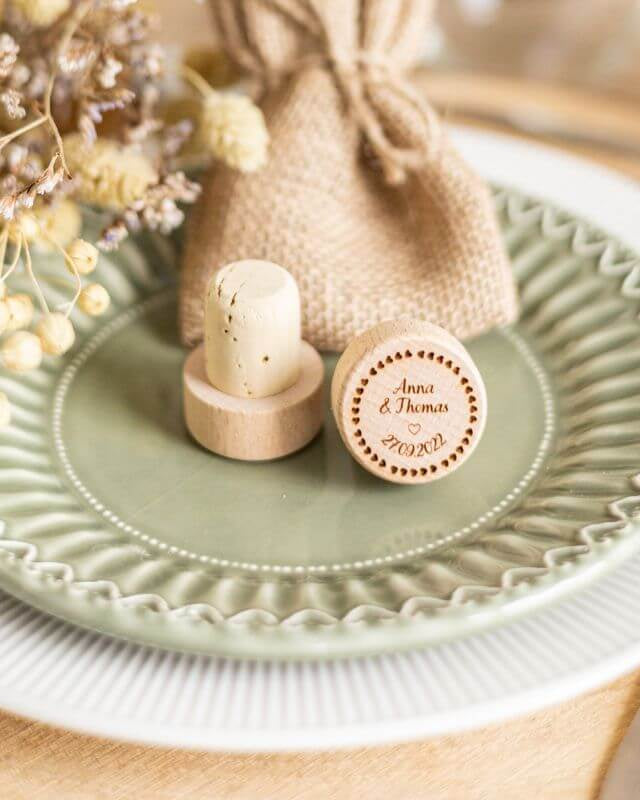 Bouchons de Vin à Personnaliser pour Mariage - My Bambou présentés sur une assiette élégante avec des fleurs séchées.