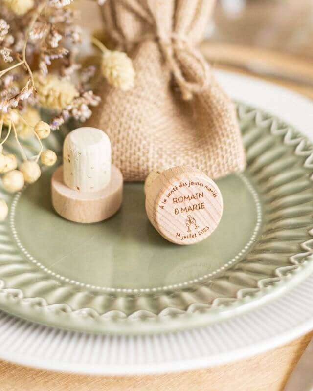 Bouchons de Vin à Personnaliser pour Mariage - My Bambou sur une assiette élégante avec des fleurs séchées.