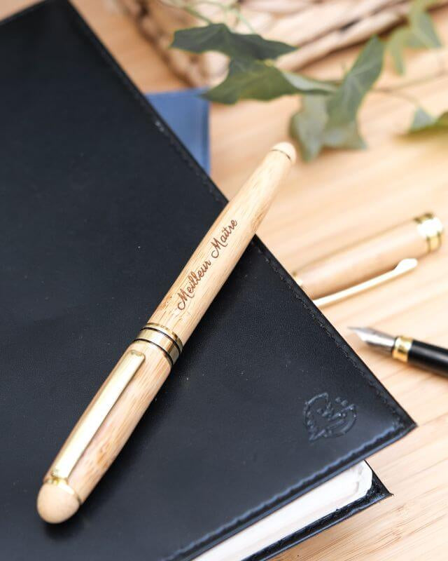 Stylo Plume à Personnaliser - My Bambou posé sur un carnet noir, mettant en valeur son design élégant et écologique.