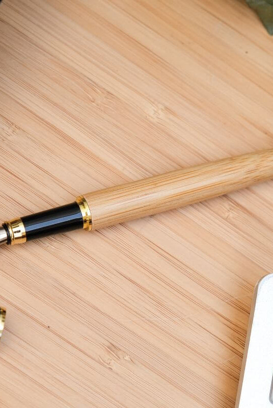Stylo Plume à Personnaliser - My Bambou sur une table en bois, mettant en avant son élégance naturelle.