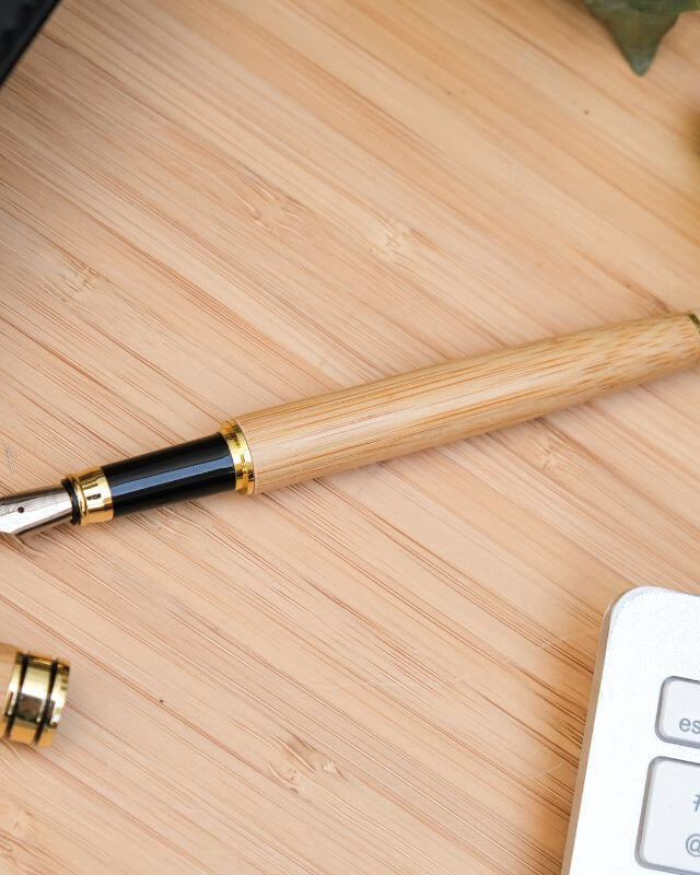 Stylo Plume à Personnaliser - My Bambou sur une table en bois, mettant en avant son élégance naturelle.