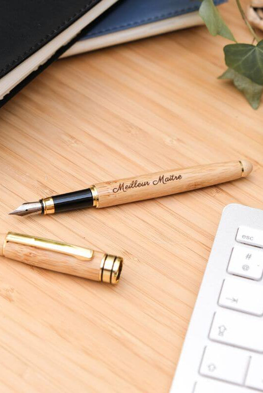 Stylo Plume à Personnaliser - My Bambou posé sur un bureau en bois avec un clavier et un carnet en arrière-plan.