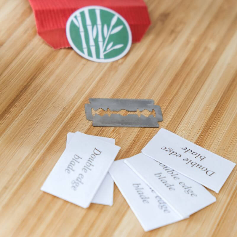 Rasoir de Sûreté à Personnaliser - My Bambou, lames double tranchant sur une surface en bois.