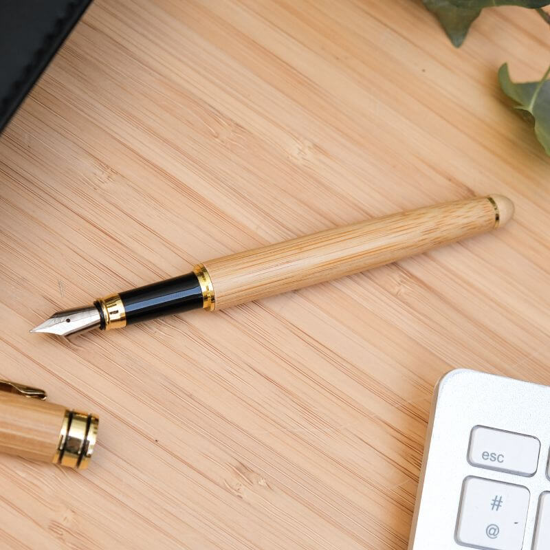 Stylo Plume à Personnaliser - My Bambou sur une table en bois, mettant en avant son élégance naturelle.