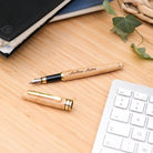 Stylo Plume à Personnaliser - My Bambou posé sur un bureau en bois avec un clavier et un carnet en arrière-plan.
